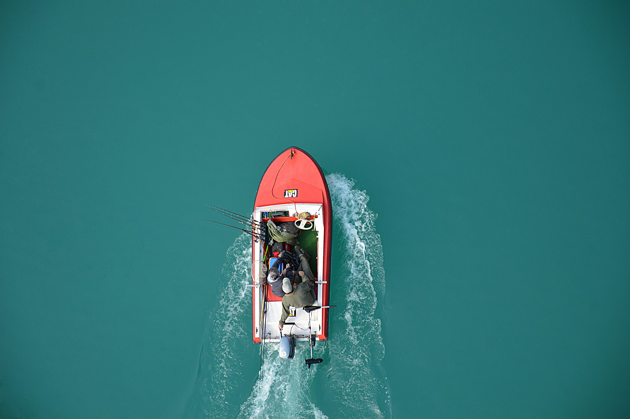 Aerial view of a small boat crossing turquoise water